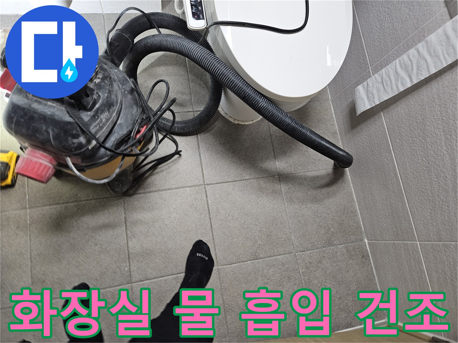 오산시 고객 댁 화장실에서-누수 엔지니어가-변기 주변의 물을-습식 청소기로 흡입하고-바닥을 건조하는 모습