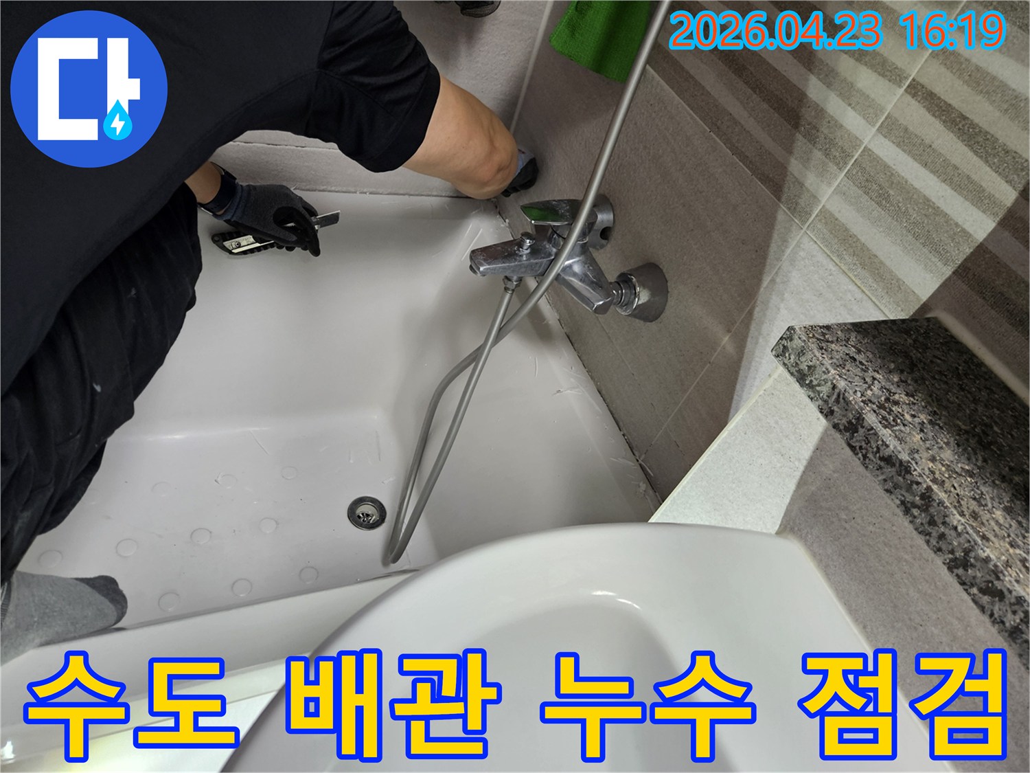 전문-엔지니어가-욕실-수도-배관-연결부위의-누수-여부를-정밀하게-점검하고-있습니다
