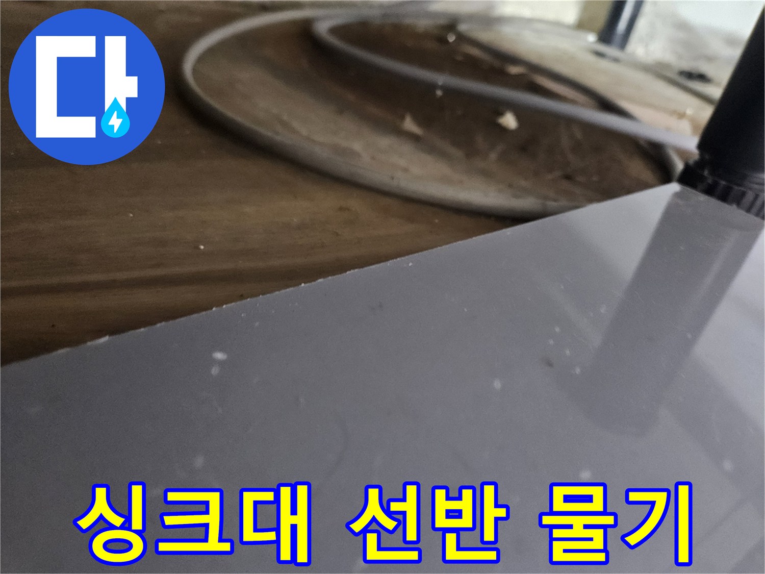 싱크대-아래-목재-선반에-맺힌-물기를-통해-누수-진행-상황을-파악하는-모습