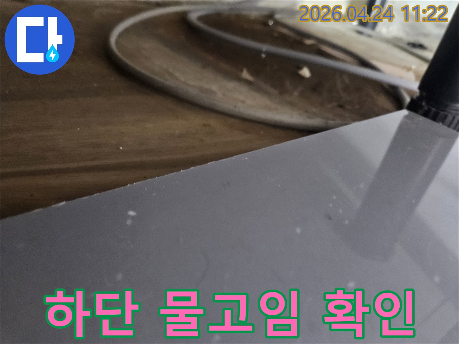 싱크대-하단-부분에서-발생한-물-고임으로-인해-주변-자재가-손상된-것을-확인하는-모습