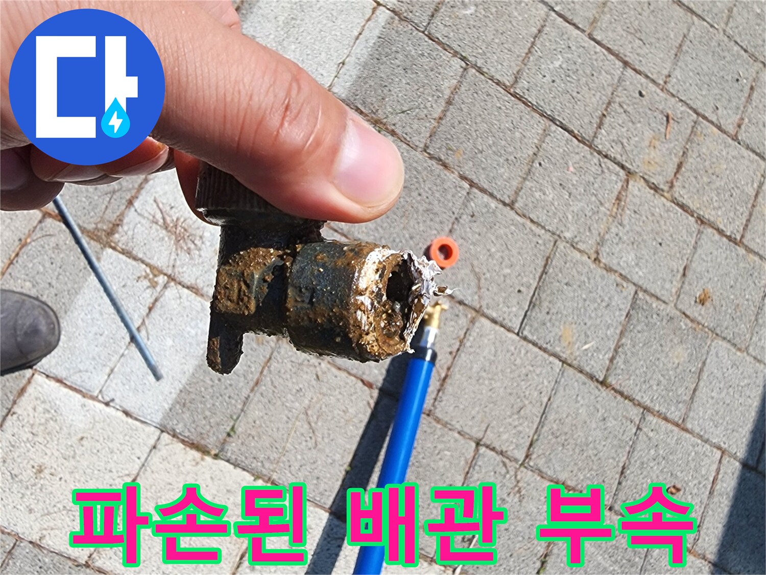 지면 아래 흙 속에서 발견된-파란색 배관과 파손된 커넥터 부품