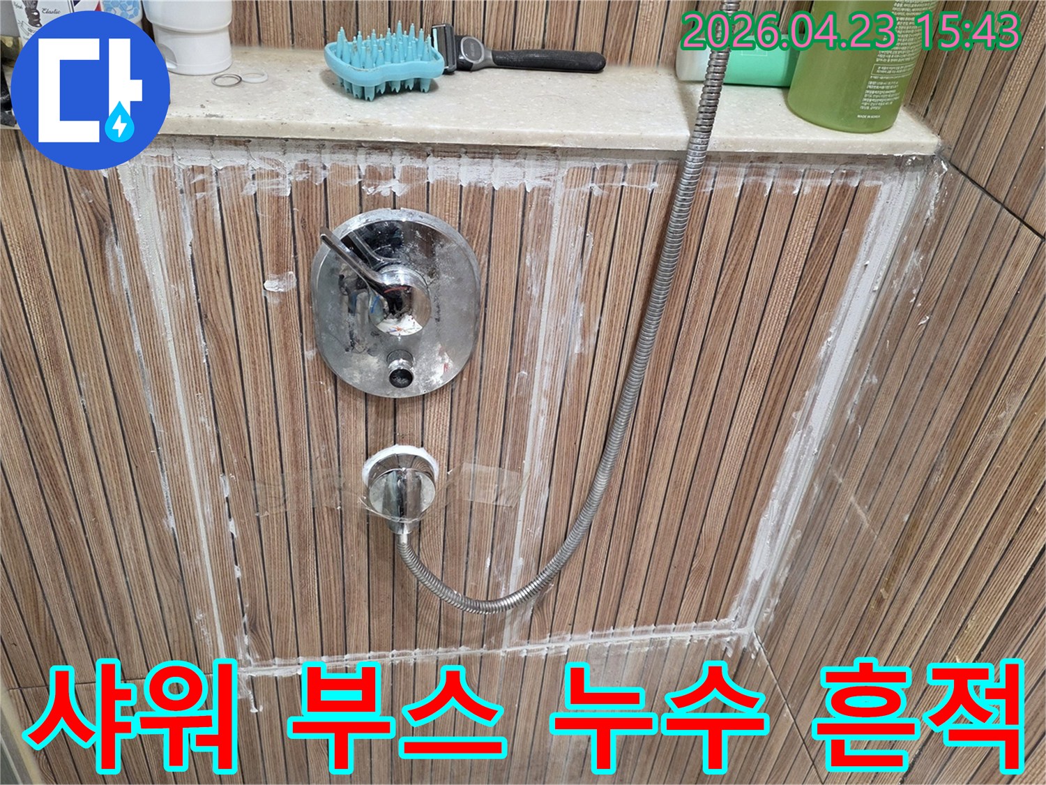욕실 샤워 부스 내 샤워 수전 주변에-물이 새어 나와-타일과 줄눈에 하얀 흔적이 남은 모습