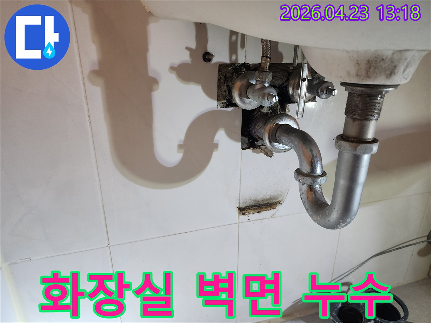 이 이미지는 양주 삼숭동 아파트 화장실 세면대 배관에서 발생한-누수로 인해 벽면에 생긴 물자국과 곰팡이 흔적을 상세히 보여줍니다.