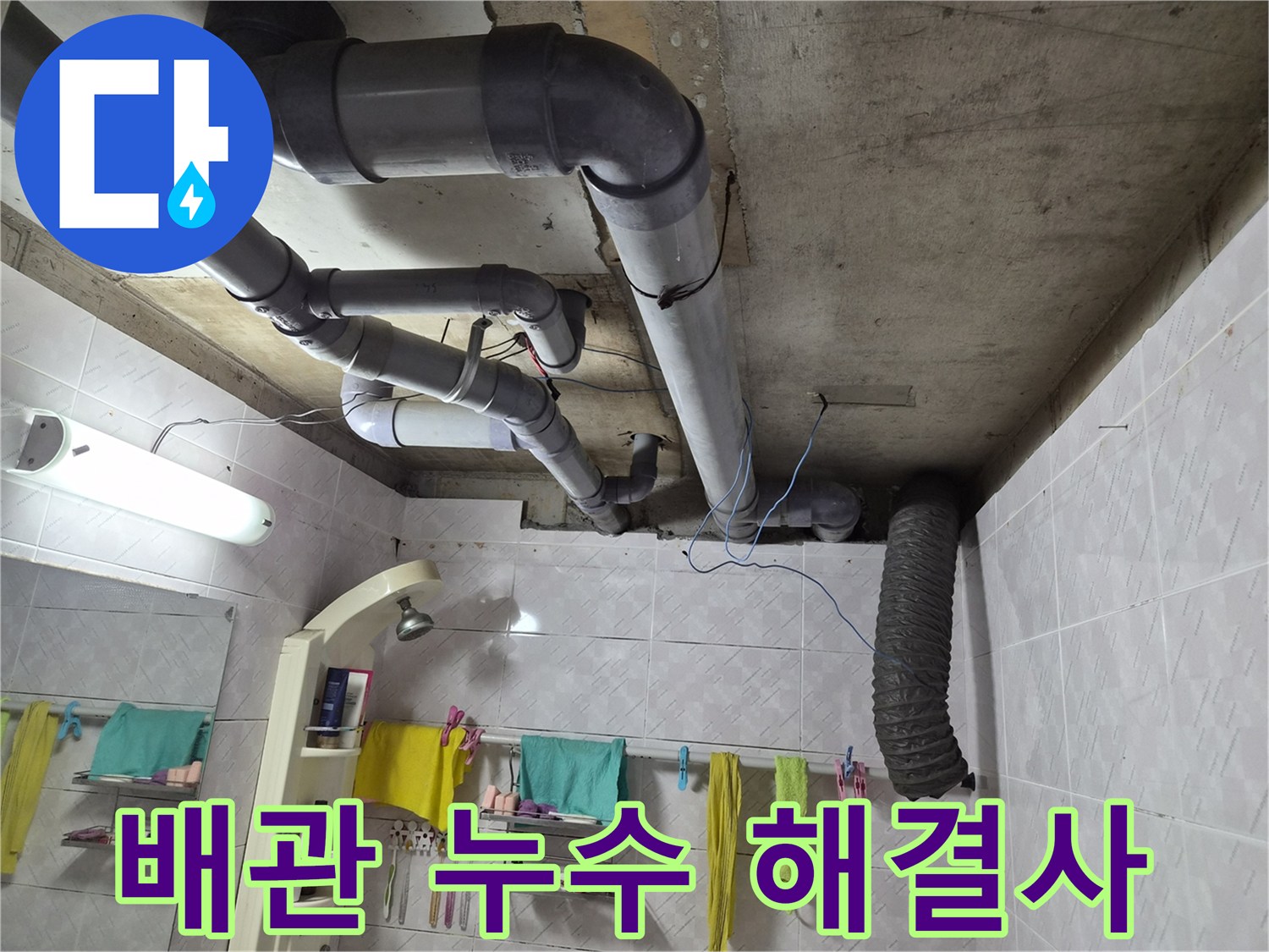 이 이미지는 욕실 천장에 노출된-배관들의 모습을 보여주며-누수 문제 해결을 위한-전문가의 현장 진단과-해결 의지를 담고 있습니다