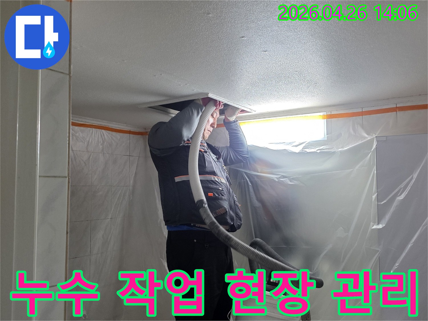 도봉구 아파트 누수 현장에서-전문 엔지니어가 안전 장비를 착용하고 천장 내부를 점검하며-주변을 비닐로 보양하여 깨끗한 작업 환경을 유지하고 있습니다