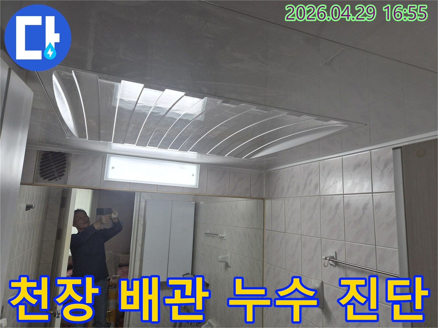욕실-천장의-돔-형태-마감재와-조명-그리고-거울에-반사된-엔지니어의-모습이-담긴-배관-누수-진단-현장-사진