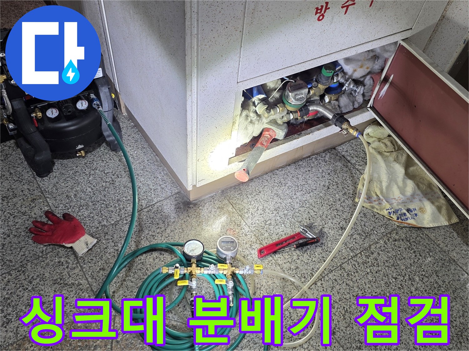 서초구 아파트 싱크대 하부장 내부의 분배기 배관을 공압 장비로 점검하는 모습