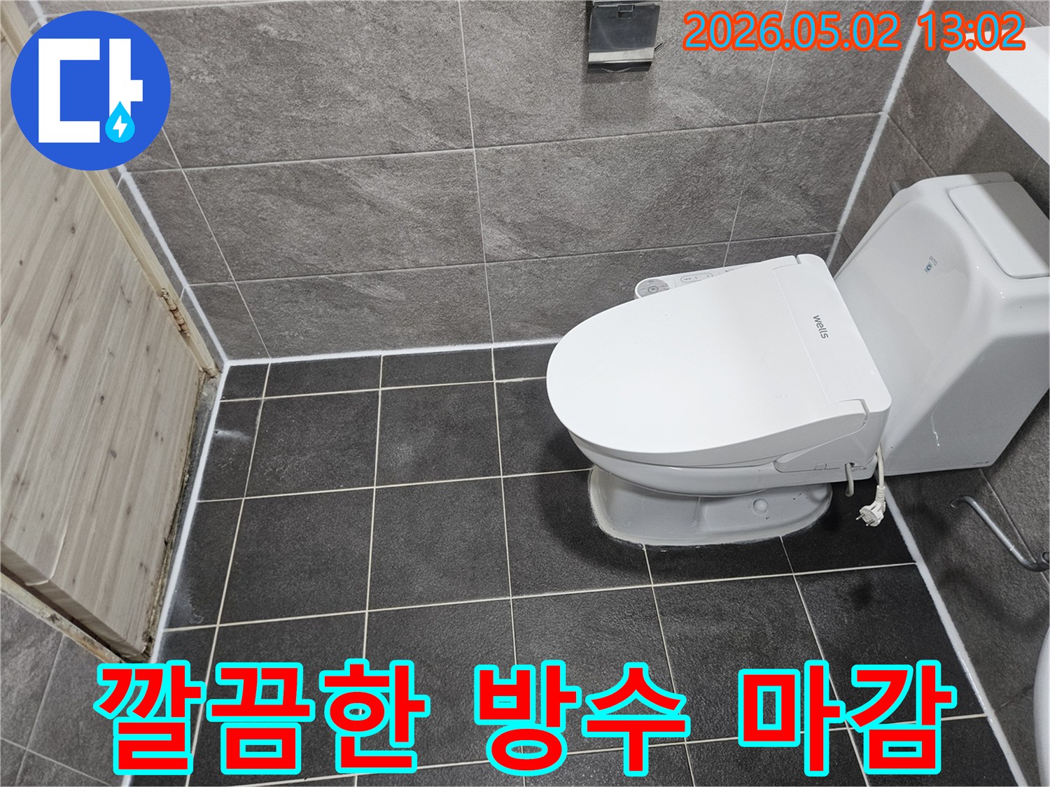 이 사진은 욕실 변기 주변과 바닥-벽 타일 경계면에 새로 시공된 깨끗하고 정돈된 실리콘 코킹을 보여줍니다.