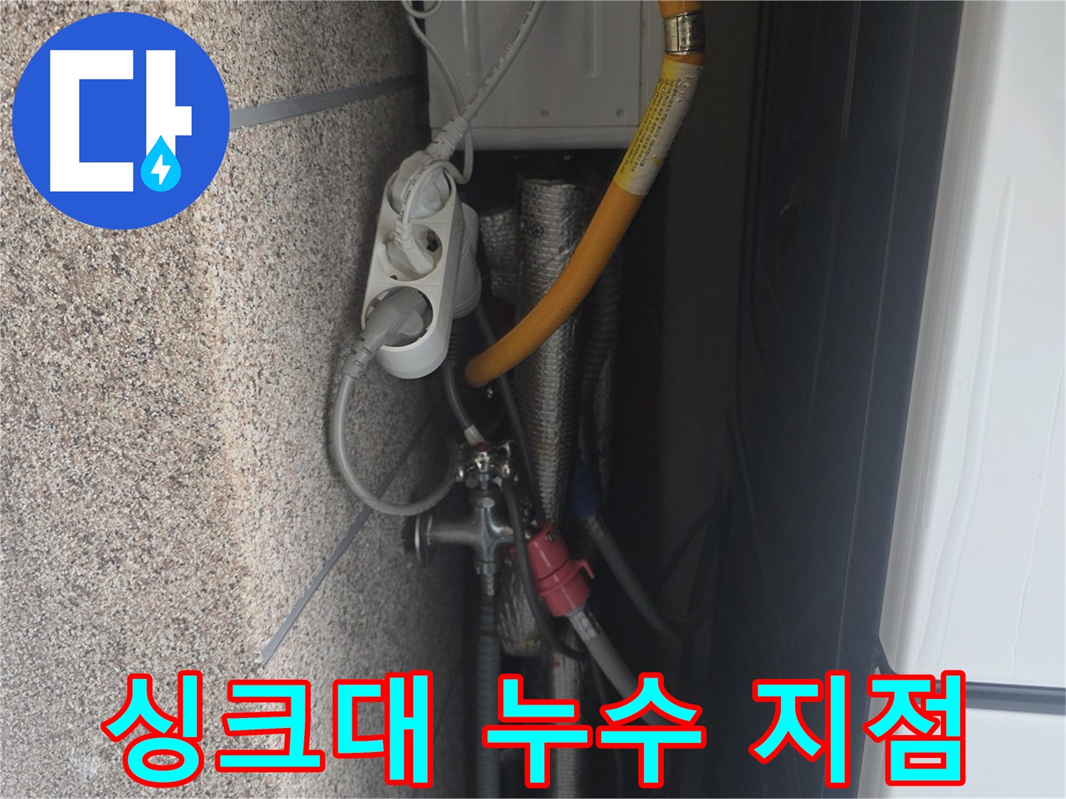 싱크대 내부 노란색 호스와 연결 부속의 근접 촬영