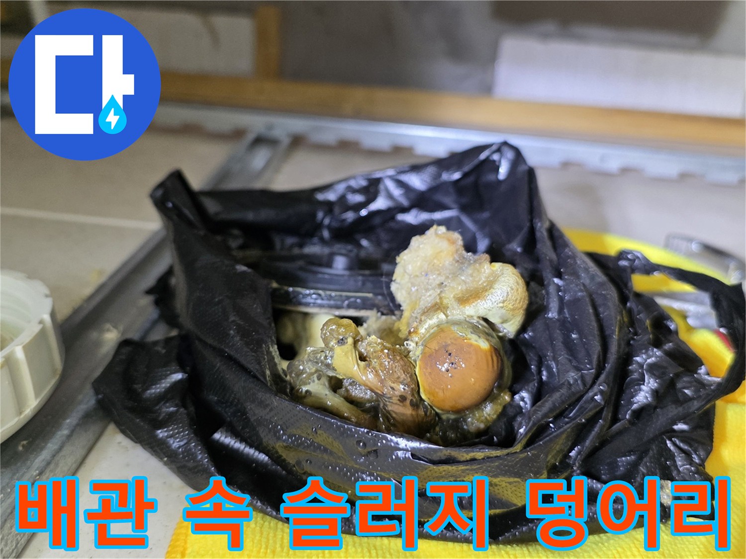 검은 비닐에 담긴-배관 내부의 거대한 슬러지 및 오염물 덩어리
