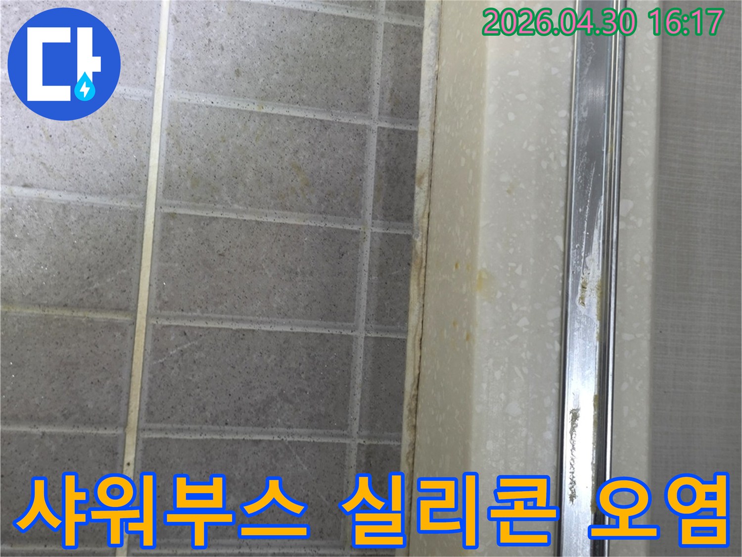 샤워부스 하단 실리콘에 물때와-곰팡이로 인한 오염이 심한 상태를 보여줍니다
