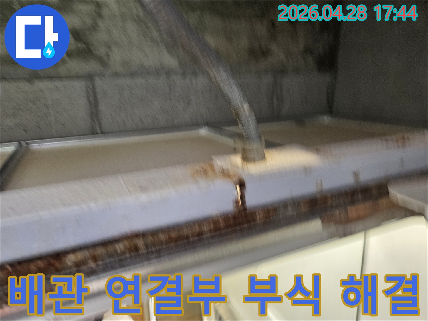 이 이미지는-배관 연결부의-부식으로-인한-누수 문제를-해결하는-공사 현장을-보여줍니다-전문가가-안전하게-작업하고-있습니다.