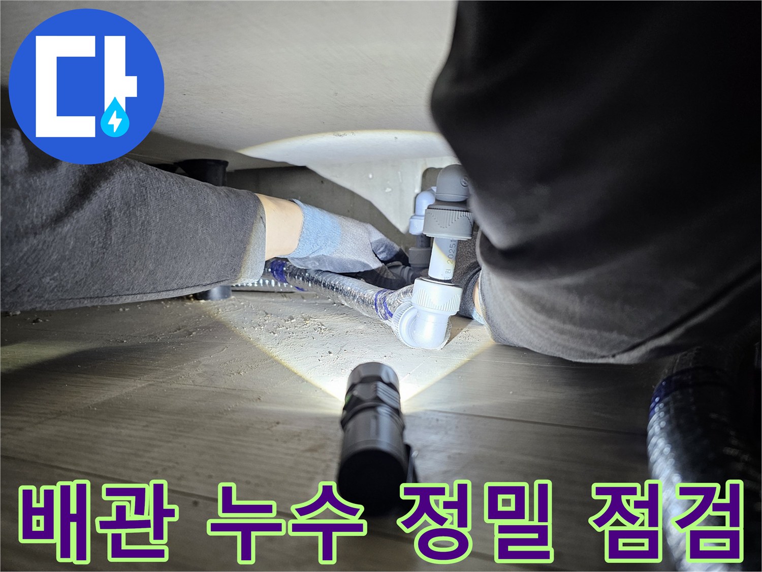 누수-탐지-전문가가-어두운-공간에서-배관-연결부를-확인하는-모습