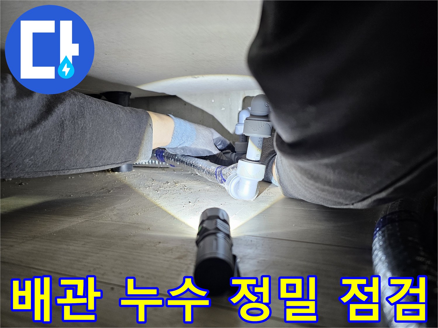 누수-탐지-전문가가-어두운-공간에서-배관-연결부를-확인하는-모습