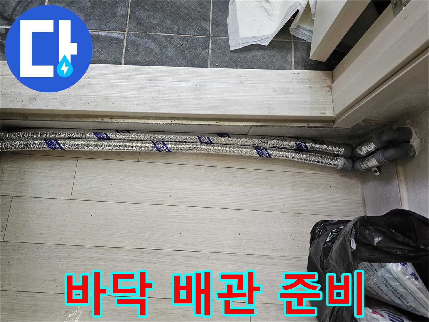 이 이미지는-남양주 진건읍 성심아트빌라-누수 배관 교체 작업을 위해-바닥 공사 전-새로운 배관 자재를-확인하는 모습을-보여줍니다