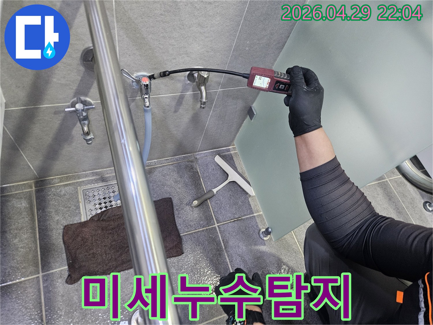 누수-전문가가-욕실-수도관-주변에서-가스-탐지기를-활용하여-미세한-누수-지점을-정확히-찾아내는-작업