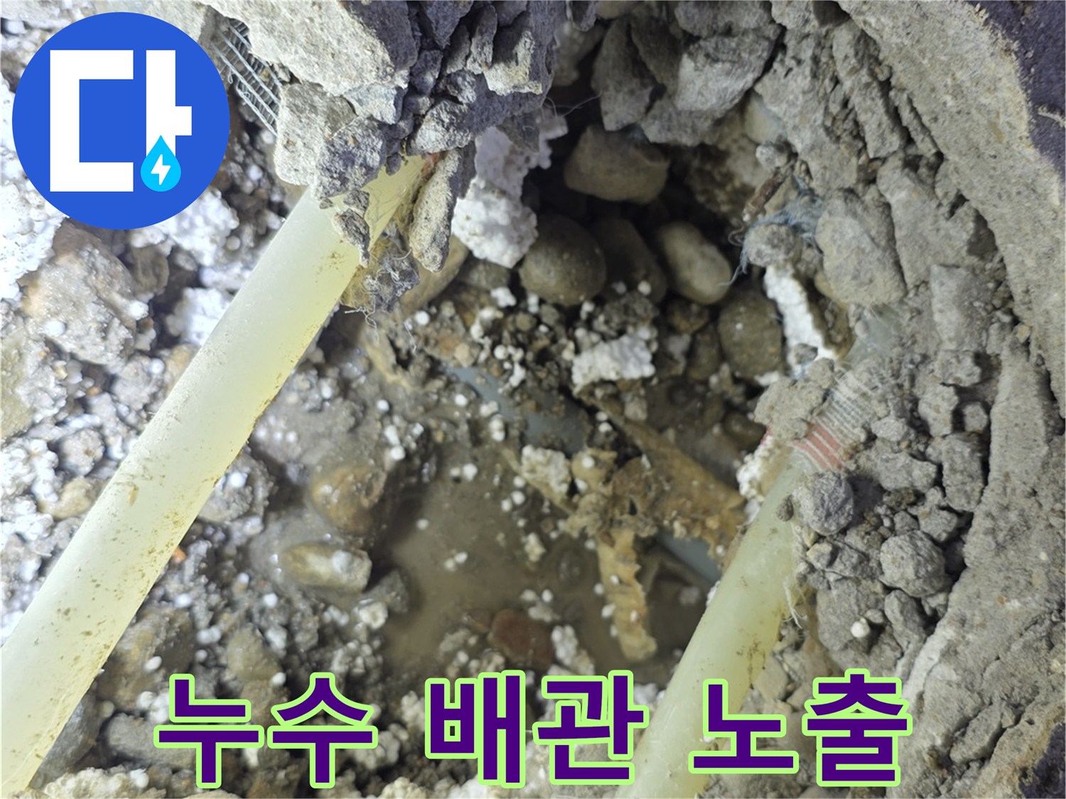 굴착 작업-노출된 배관과 주변의 젖은 토사 및 콘크리트