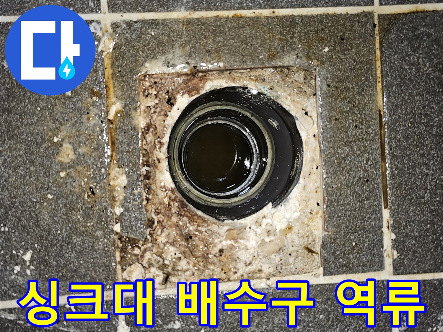 싱크대 배수구에서-오수가 역류하여 바닥에 고여있는-심각한 배관 막힘 현장을 보여주는 사진입니다.
