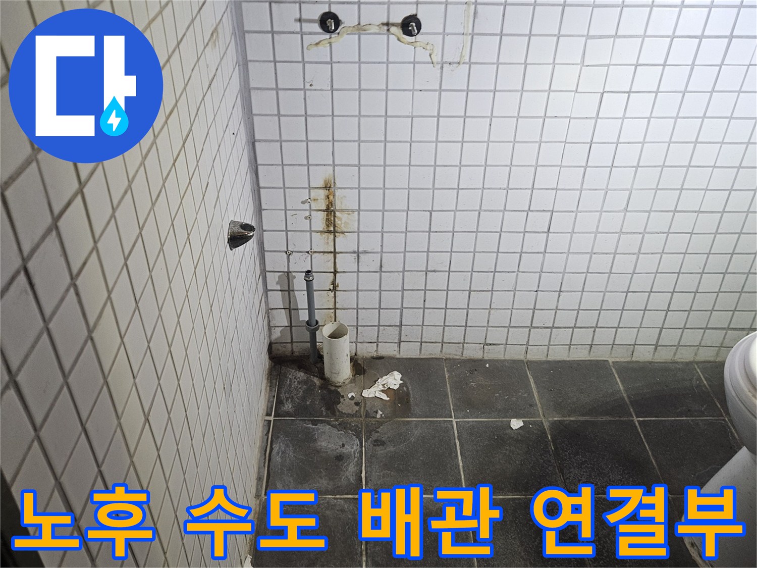 세면대 탈거 작업 후-욕실 벽면에 노출된-노후화된 수도 배관 연결부와-주변의 누수 흔적을-정밀하게 검사하는-누수 전문가