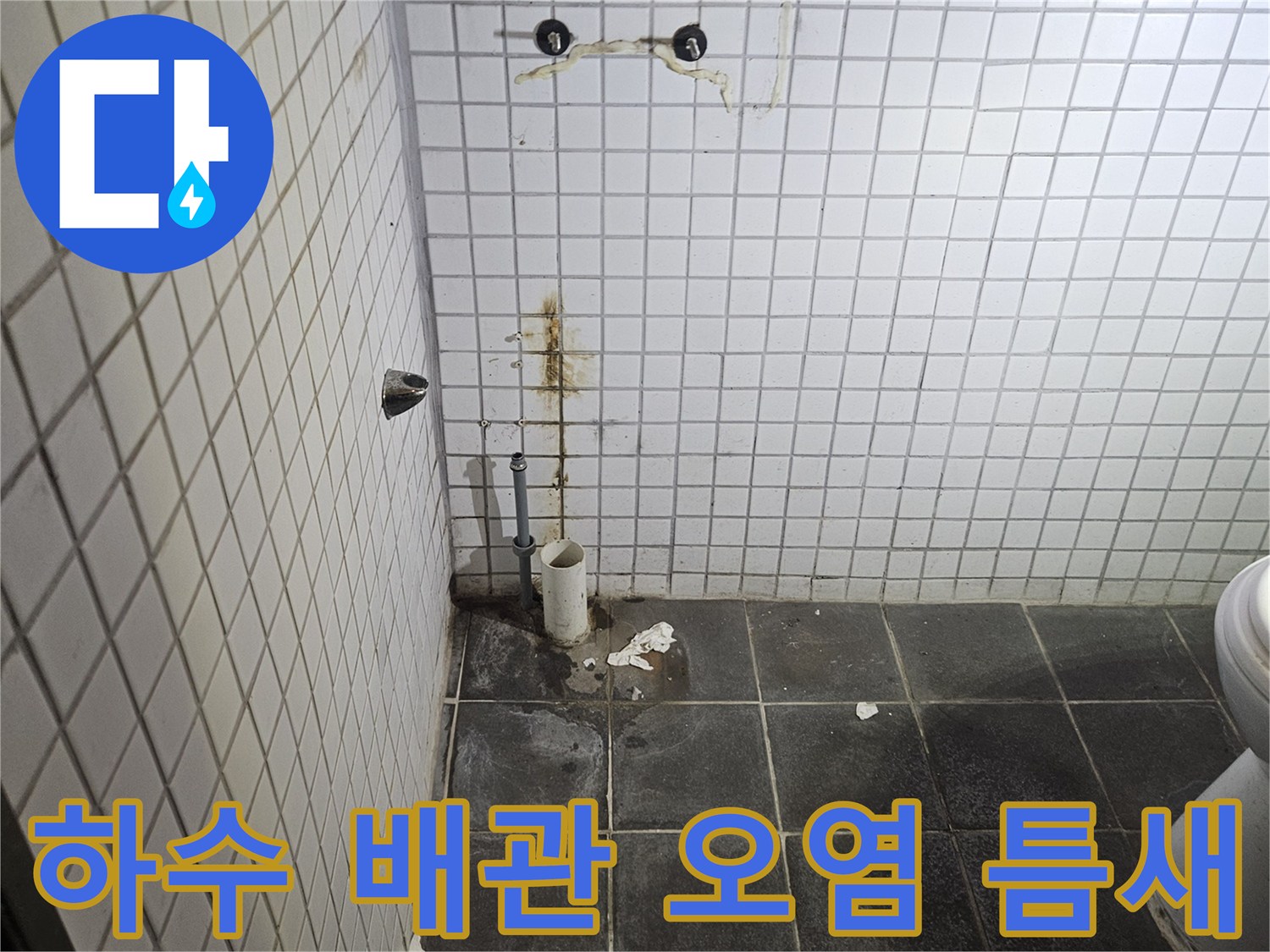 세면대 탈거 후-욕실 검은색 타일 벽면에-노출된 하수 배관 연결부의-심각한 오염과-틈새를 정밀하게-진단하는 누수 전문가