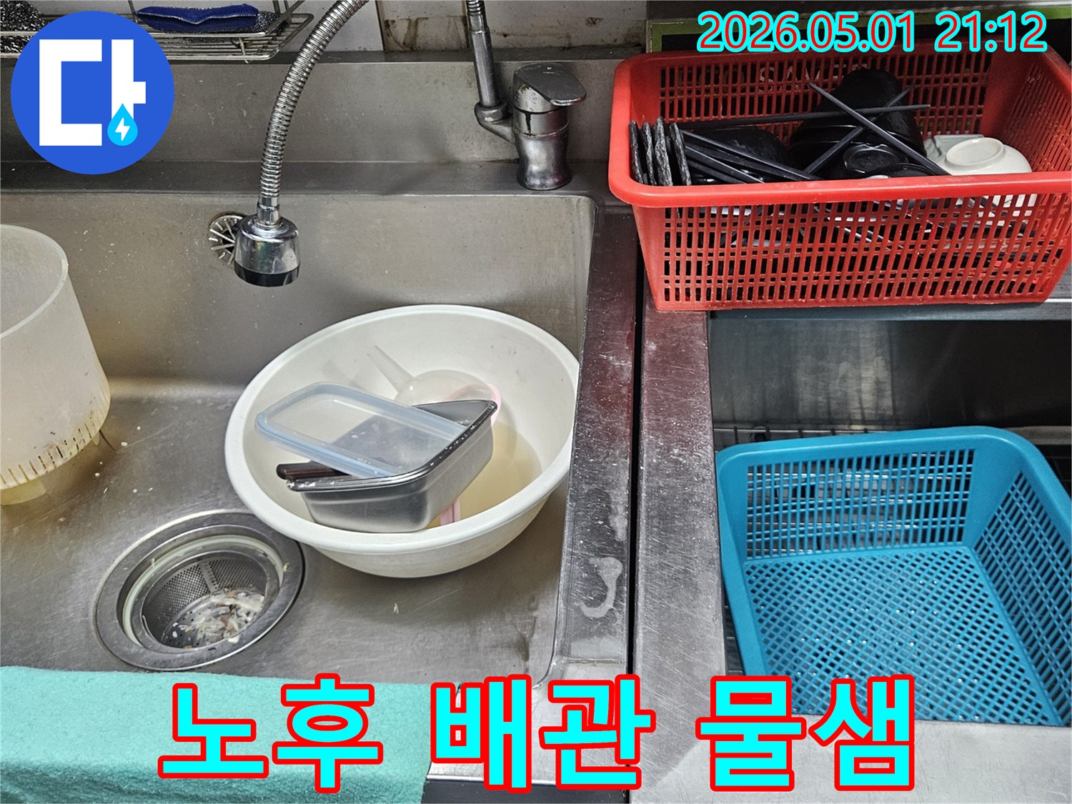 오래된 주방 싱크대 배관에서-물이 새어 나와-주변에 물때가 형성된 모습