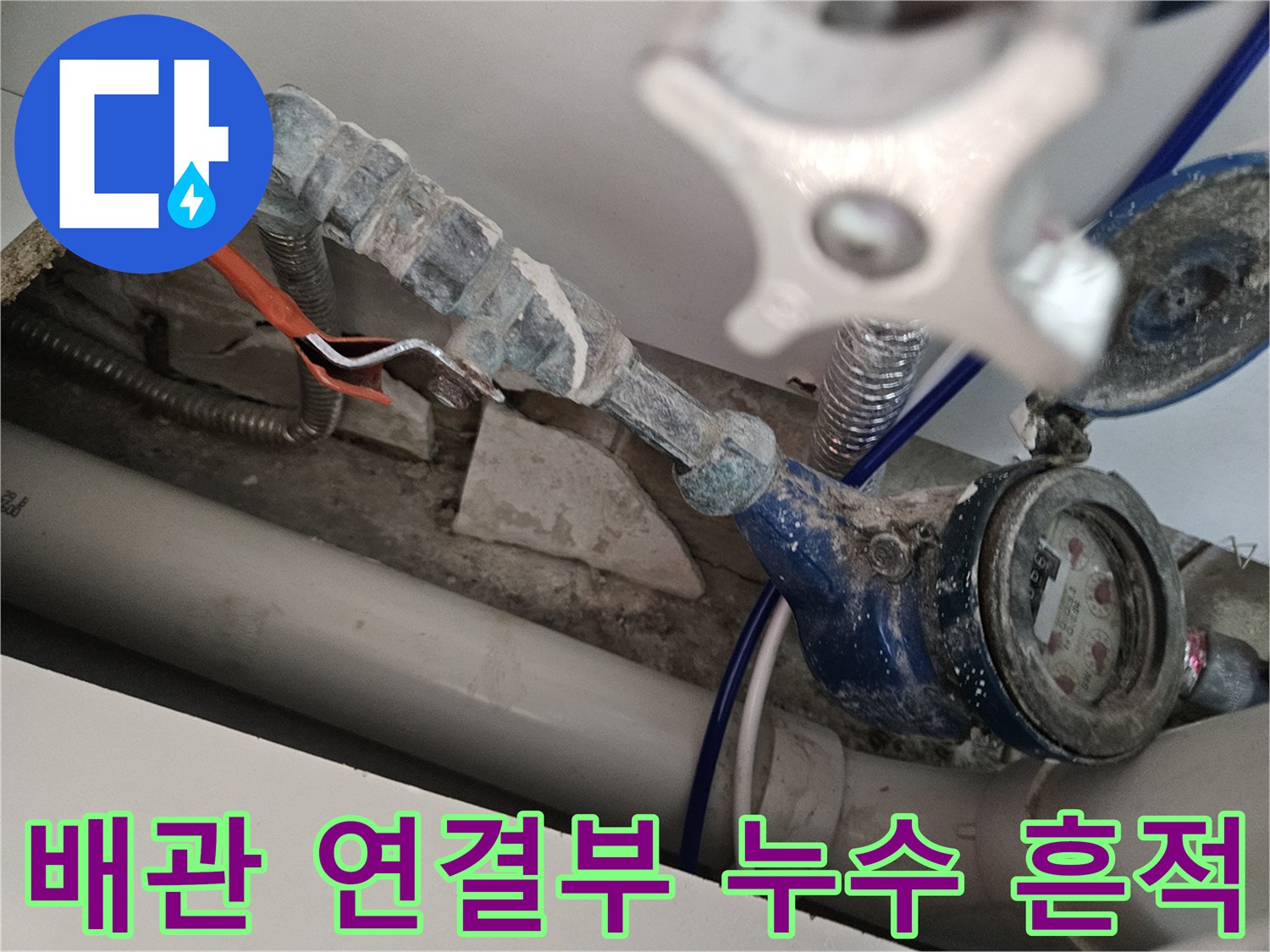 수도 계량기 주변의 누수로 인한 하얀 석회 자국과 오염된 배관