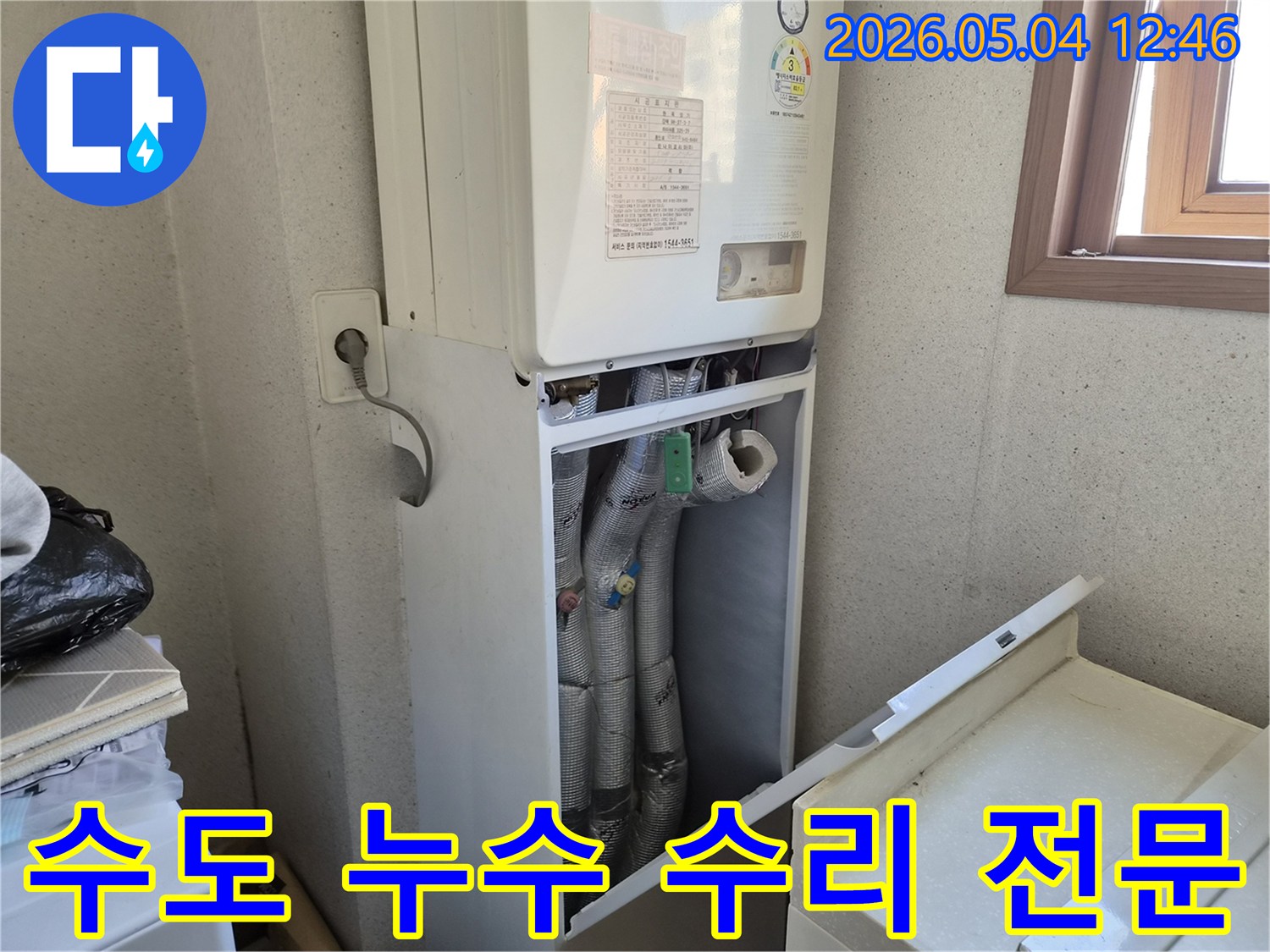 금호동 아파트 보일러실에서-수도 배관 누수 수리 전문가가-하단 커버를 개방하여-배관 상태를 점검하는 모습입니다