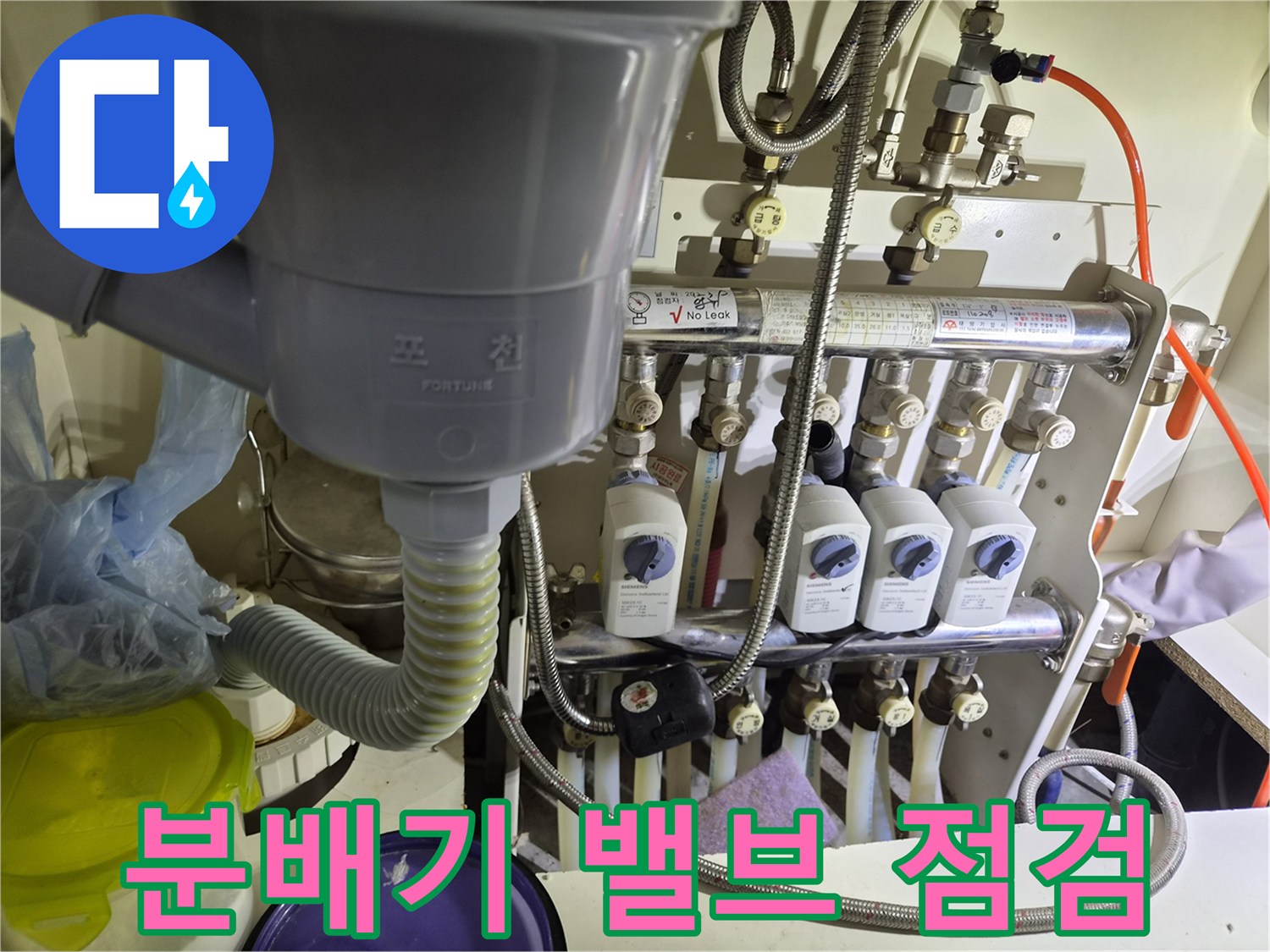 흰색 밸브와 은색 호스가 연결된 분배기 배열 모습