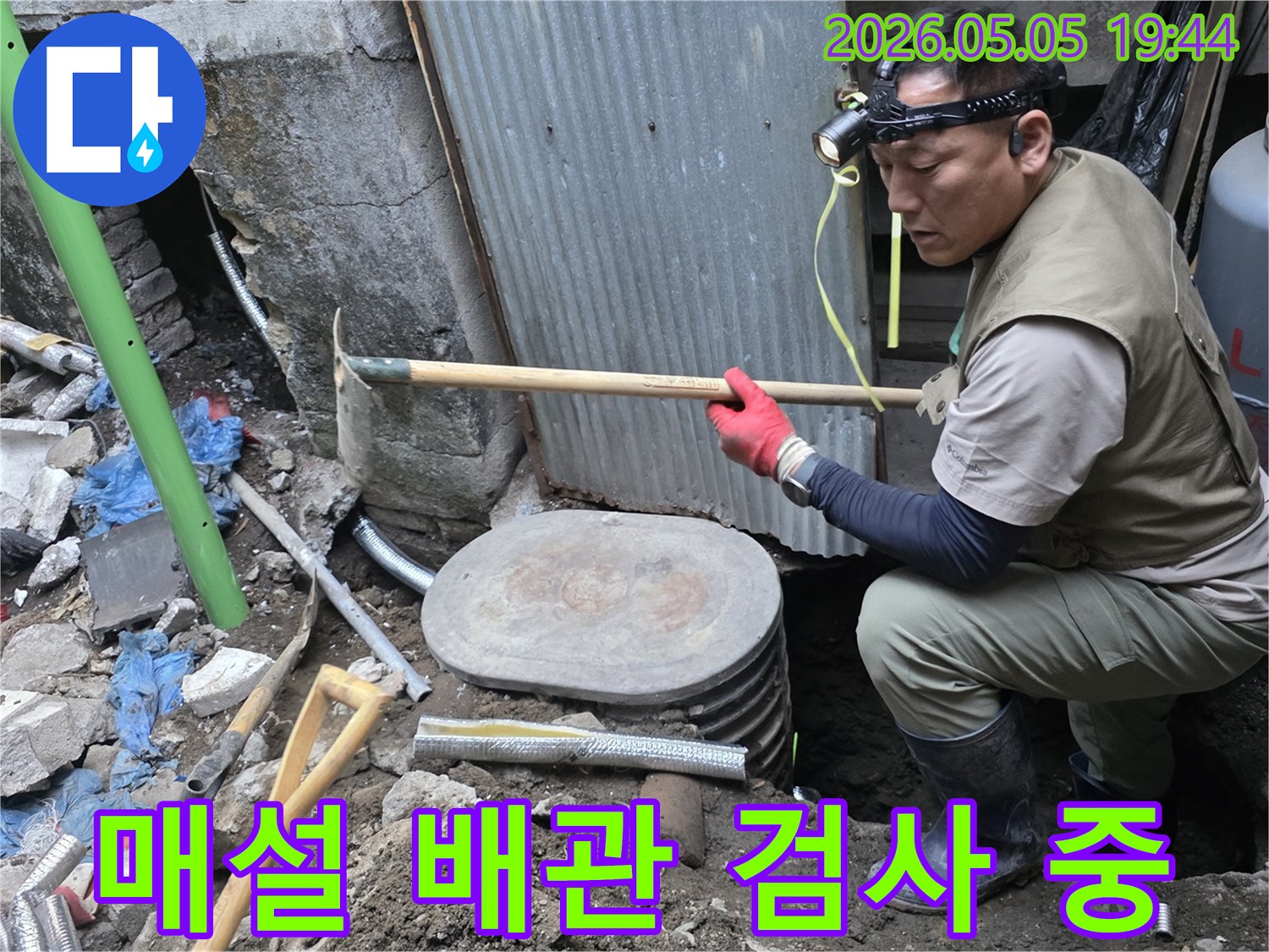 수도관 누수 탐지를 위해-흙을 파내고 드러난 배관을-전문 장비를 활용하여 검사하는 현장 사진