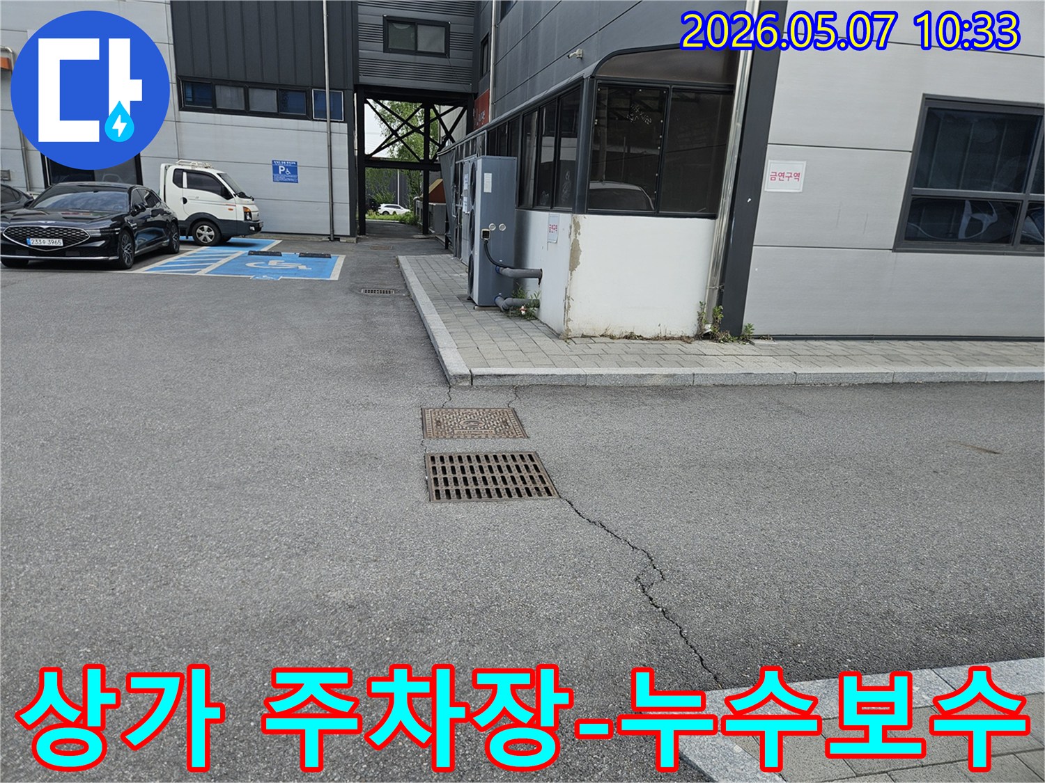이 이미지는 의정부 만가대길 상가 주차장의 아스팔트 균열과-맨홀-배수구 주변의 지반 문제를 보여줍니다.