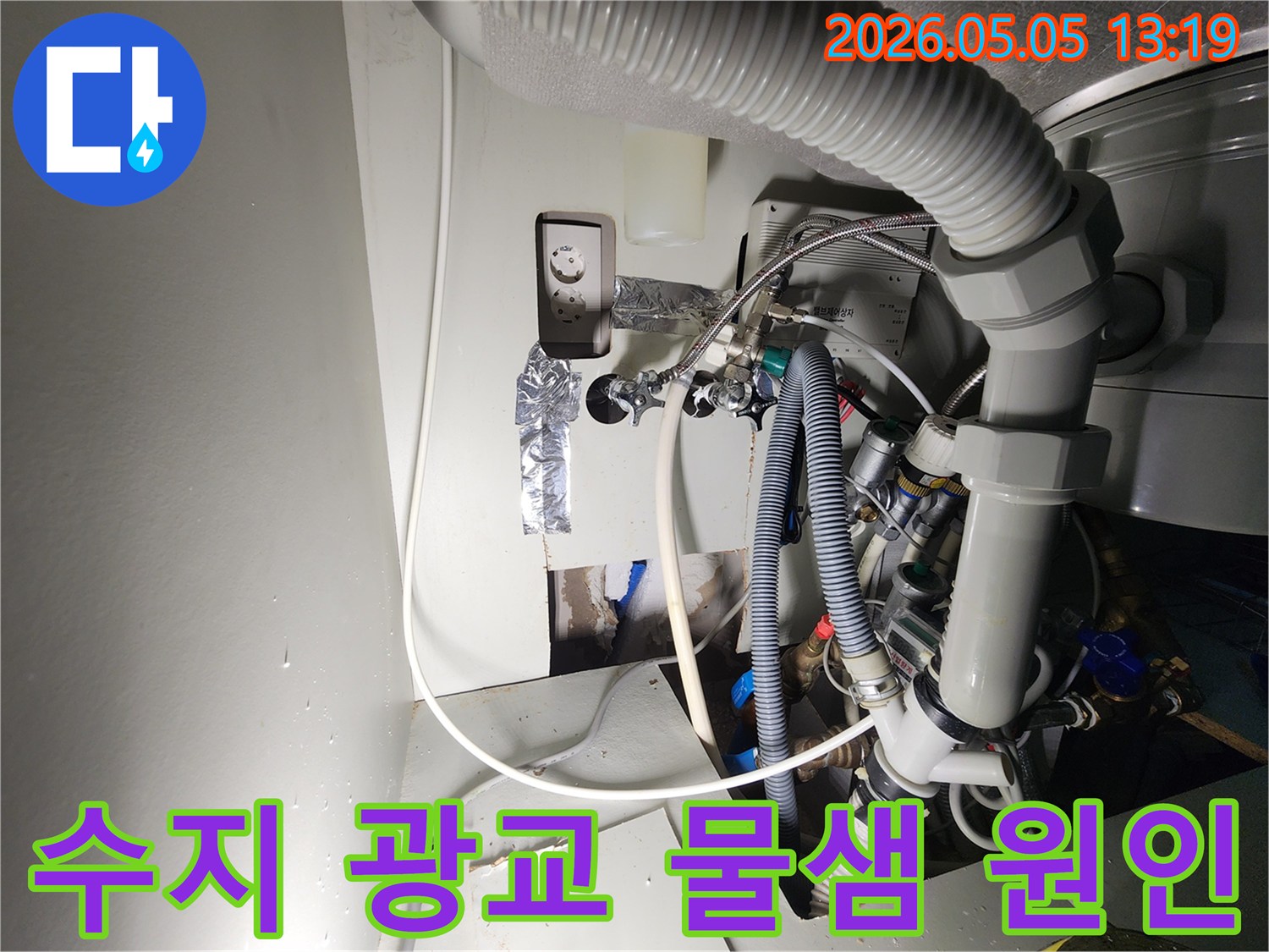 이 이미지는-수지구-광교-아파트에서-발생한-물샘-현장을-보여주며-벽면을-개방한-뒤-드러난-복잡한-배관과-전기-시설-사이에서-물이-떨어지는-모습을-촬영한-것입니다