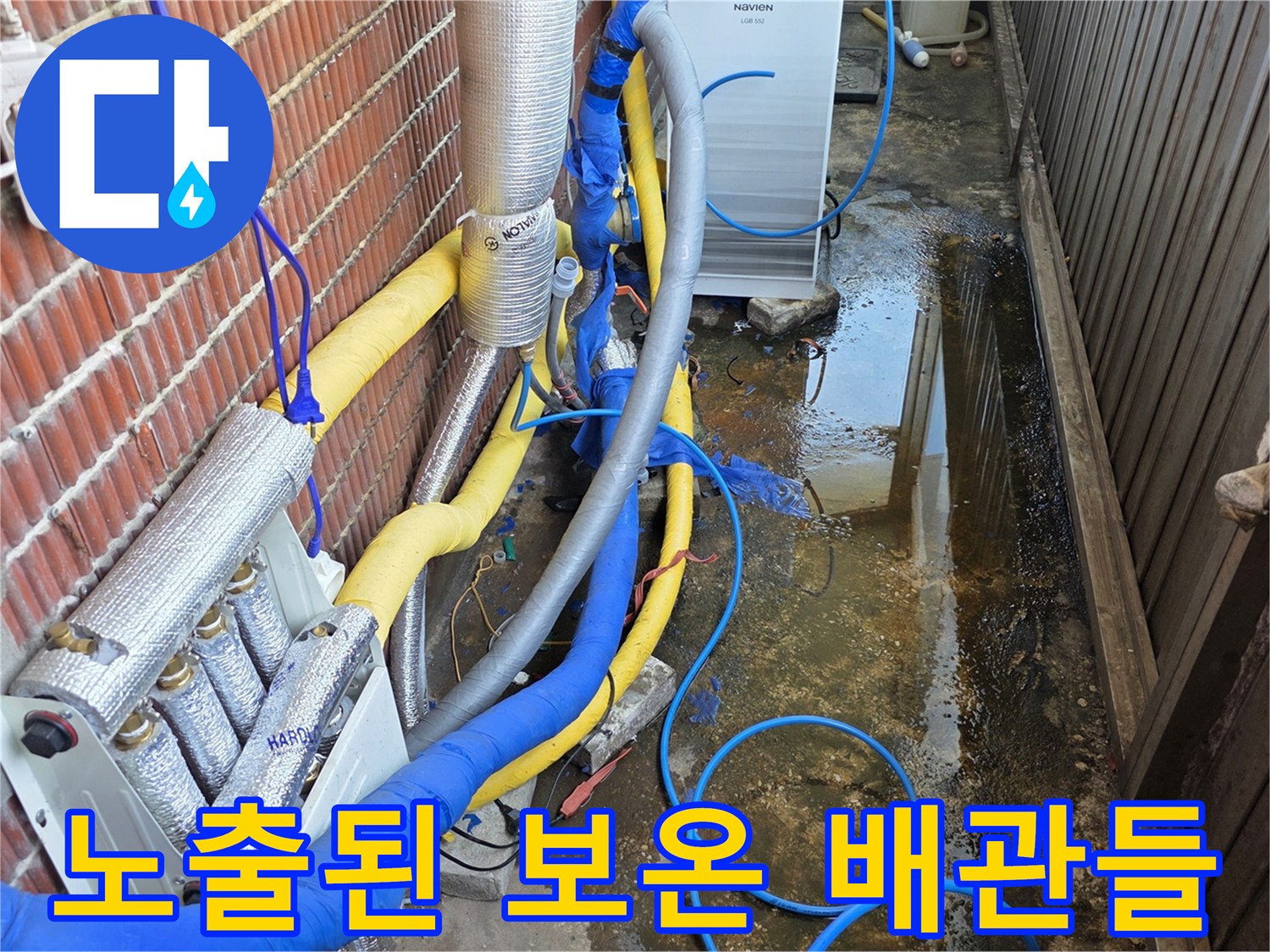 보온재로 마감된 외부 노출 배관과 파란색 호스 연결 부위
