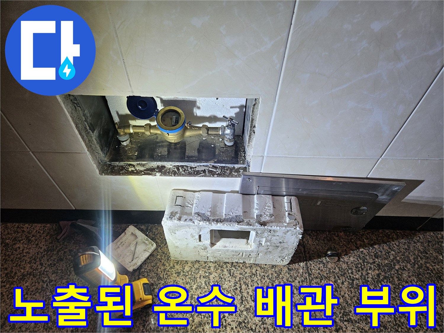 타일 제거 후 나타난 젖은 상태의 배관 연결 부속과 주변부