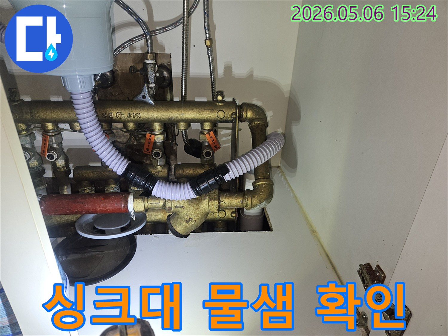 이 이미지는 주방 싱크대-하부장 내부에서 발생한-물샘 현상을 확인하고-누수 지점을 파악하는-전문적인 점검 과정을-보여주고 있습니다.