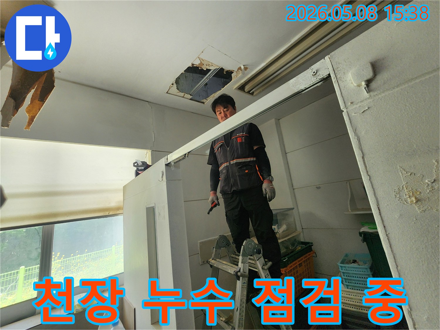 누수 전문가가 사다리 위에서-천장 누수 지점을-세밀하게 검사하고 있습니다