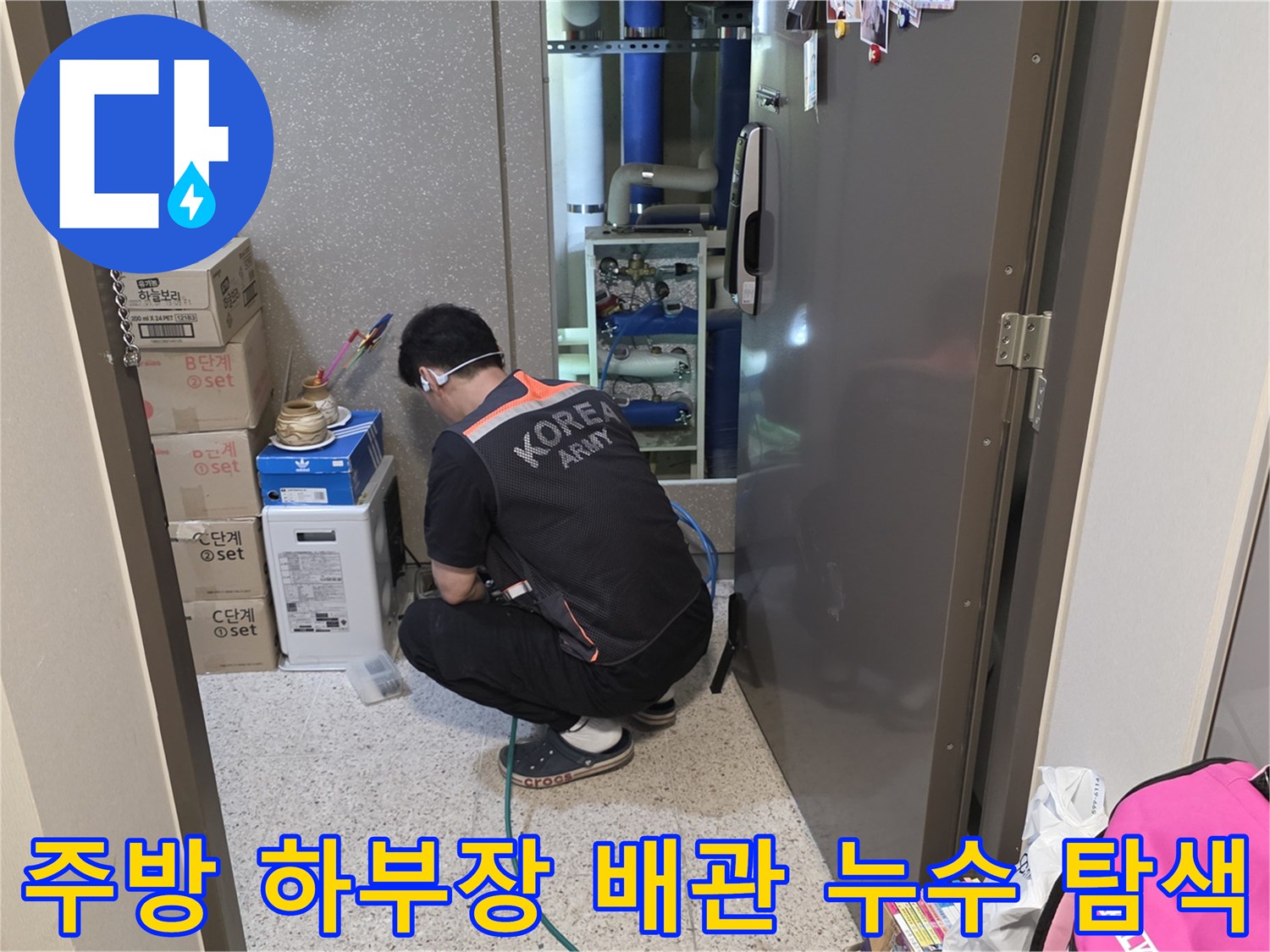 싱크대 하부장 내 보일러 분배기 주변을 점검하는 작업자