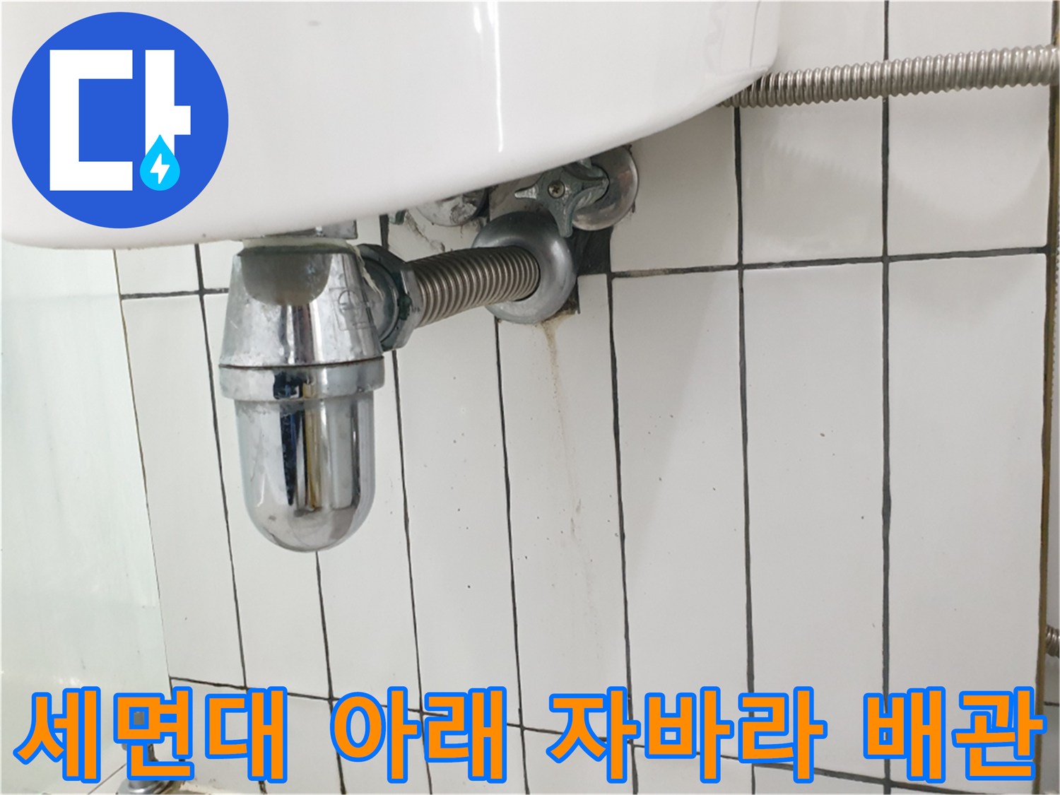 세면대 하단에 노출된 금속 재질의 배수관 사진