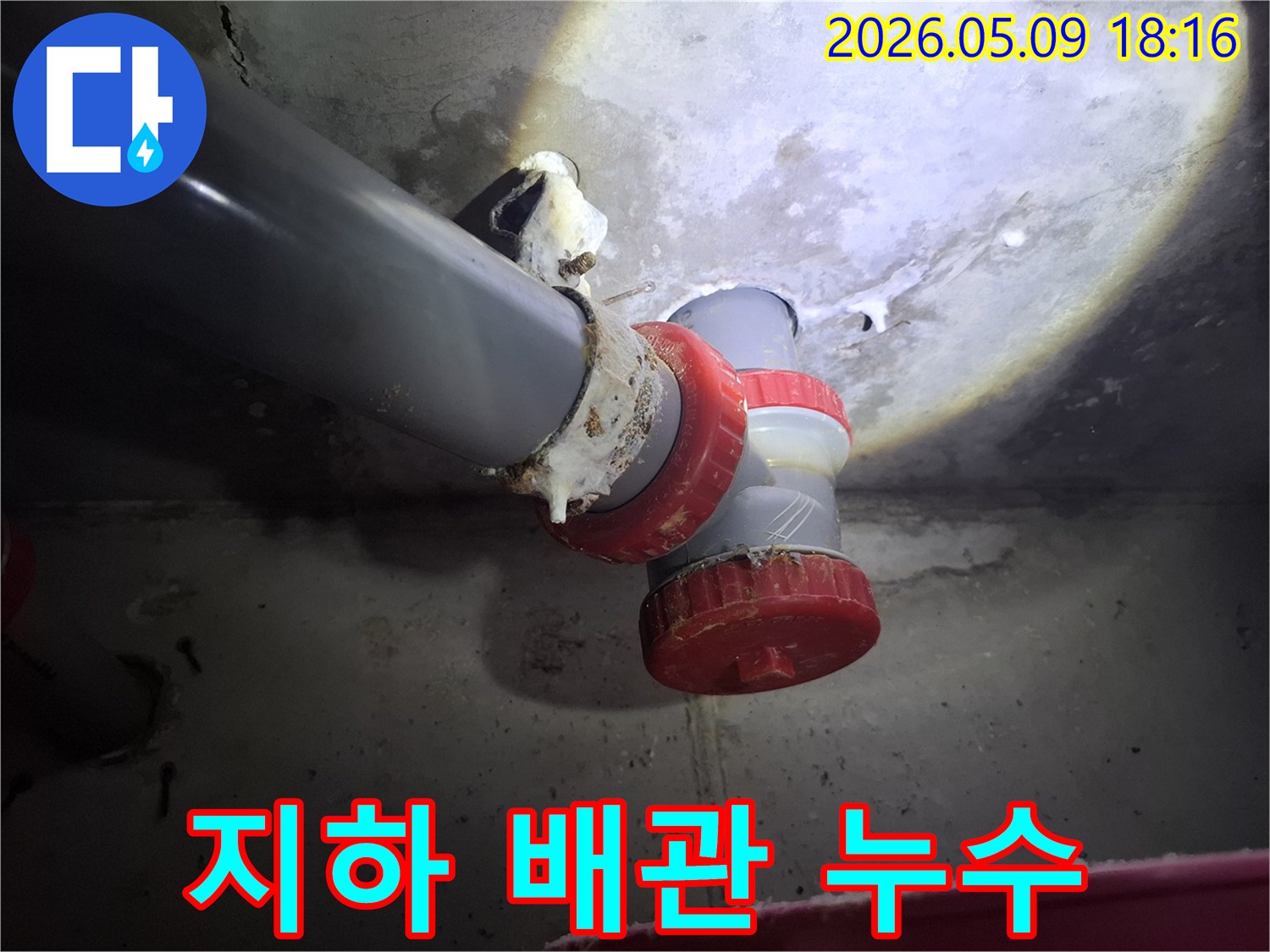 지하 배관 연결 부위에서-물이 새어 나와-하얀 침전물이 형성된-누수 현장의 모습입니다