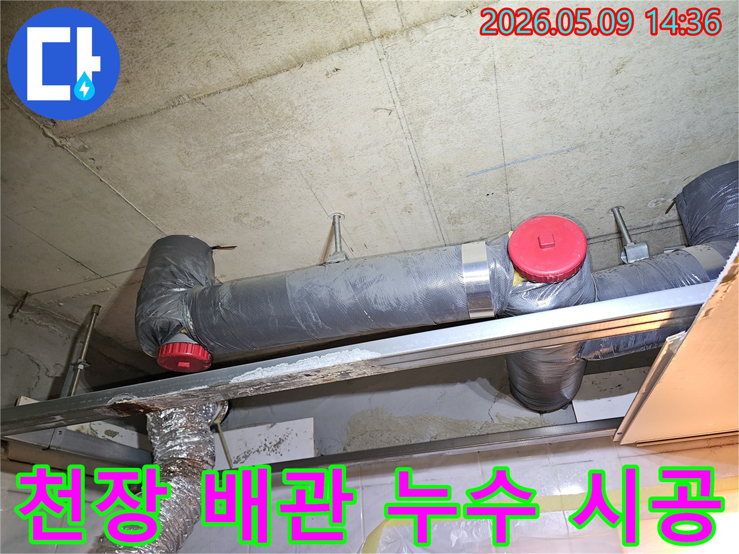 천장 배관에서 발생한 누수를 해결하기 위해-전문가가 보수 작업을 준비하고 있는 모습입니다