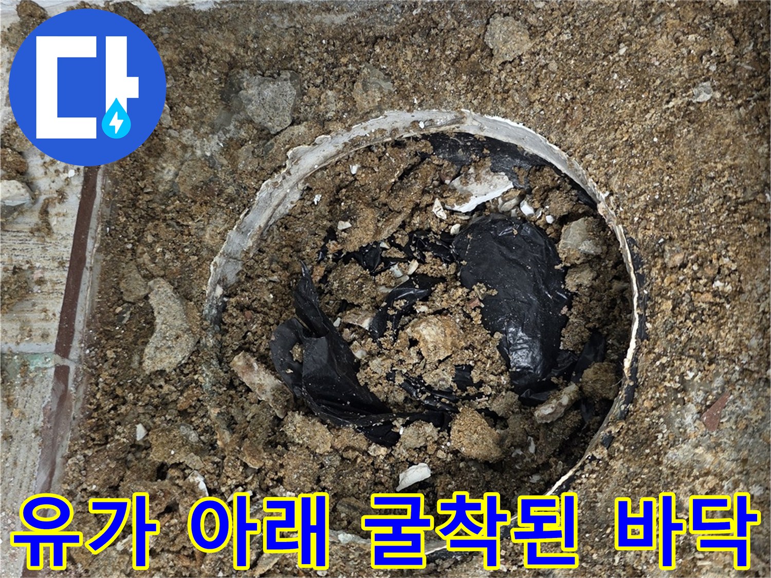 배수구 주변의 젖은 흙과 노출된 배관 부위
