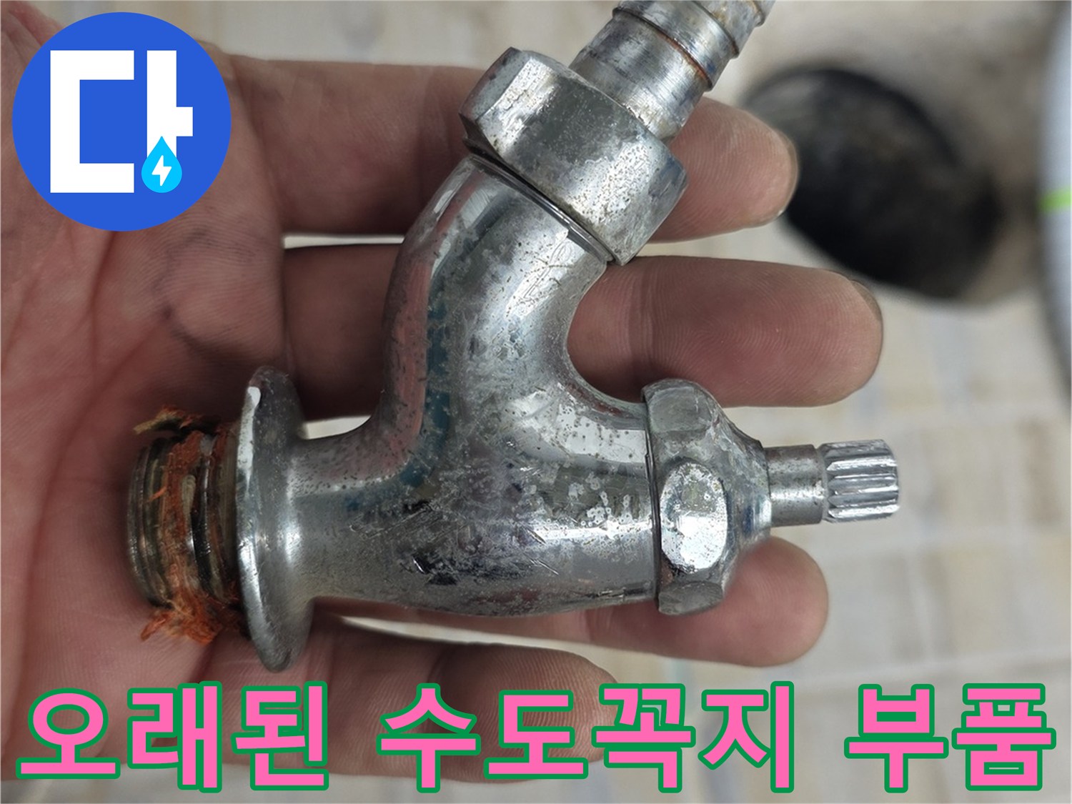 손으로 잡고 있는 낡은 수도꼭지 연결부