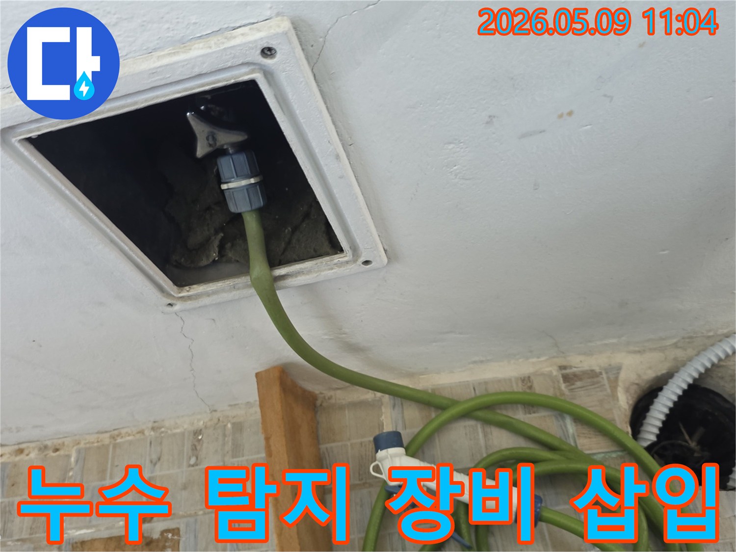 천장 점검구를 통해 누수 탐지용 장비 호스를 삽입하여 내부 상태를 확인 중
