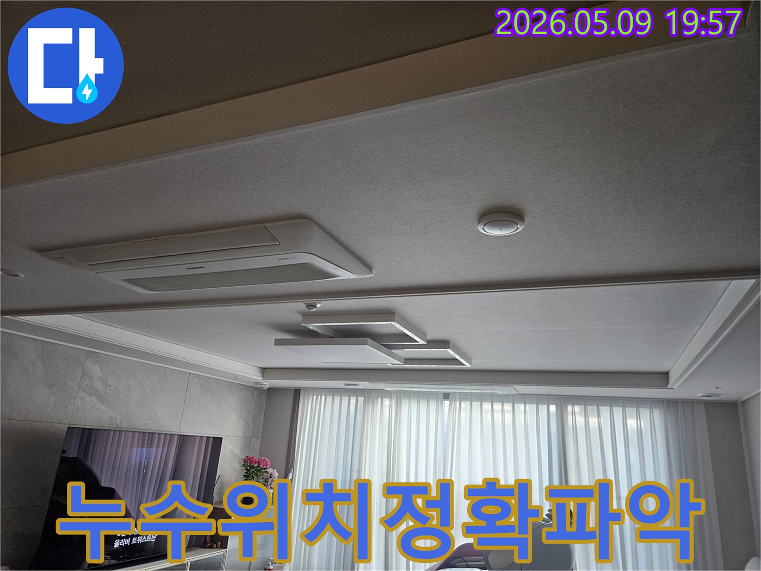 고객님 댁 거실 천장의 모습으로-시스템 에어컨과 조명 사이에서-누수 지점을 정확히 파악하기 위한-초기 점검이 이루어지는 현장입니다.