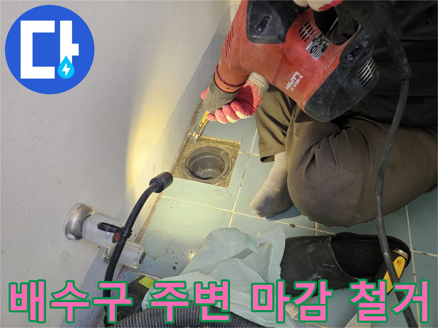 드릴 작업으로-손상된 배수구 주변 타일을 제거하는 모습