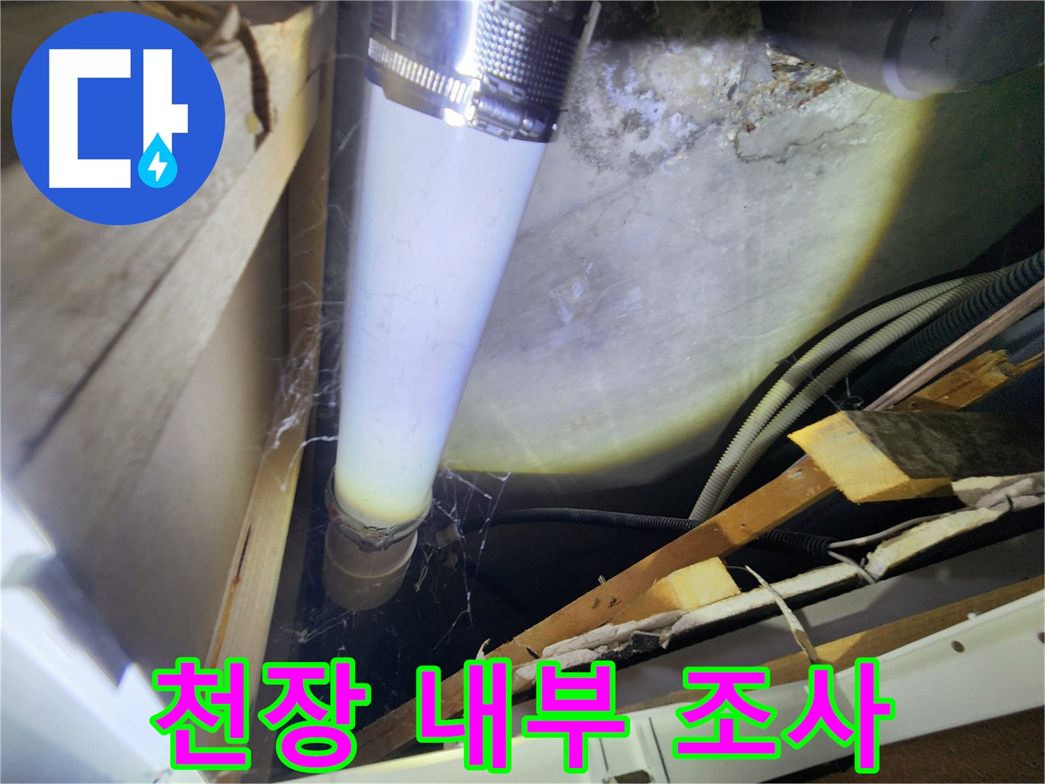 조명에 밝게 비춰진 천장 속 PVC 배관과 주변 자재들