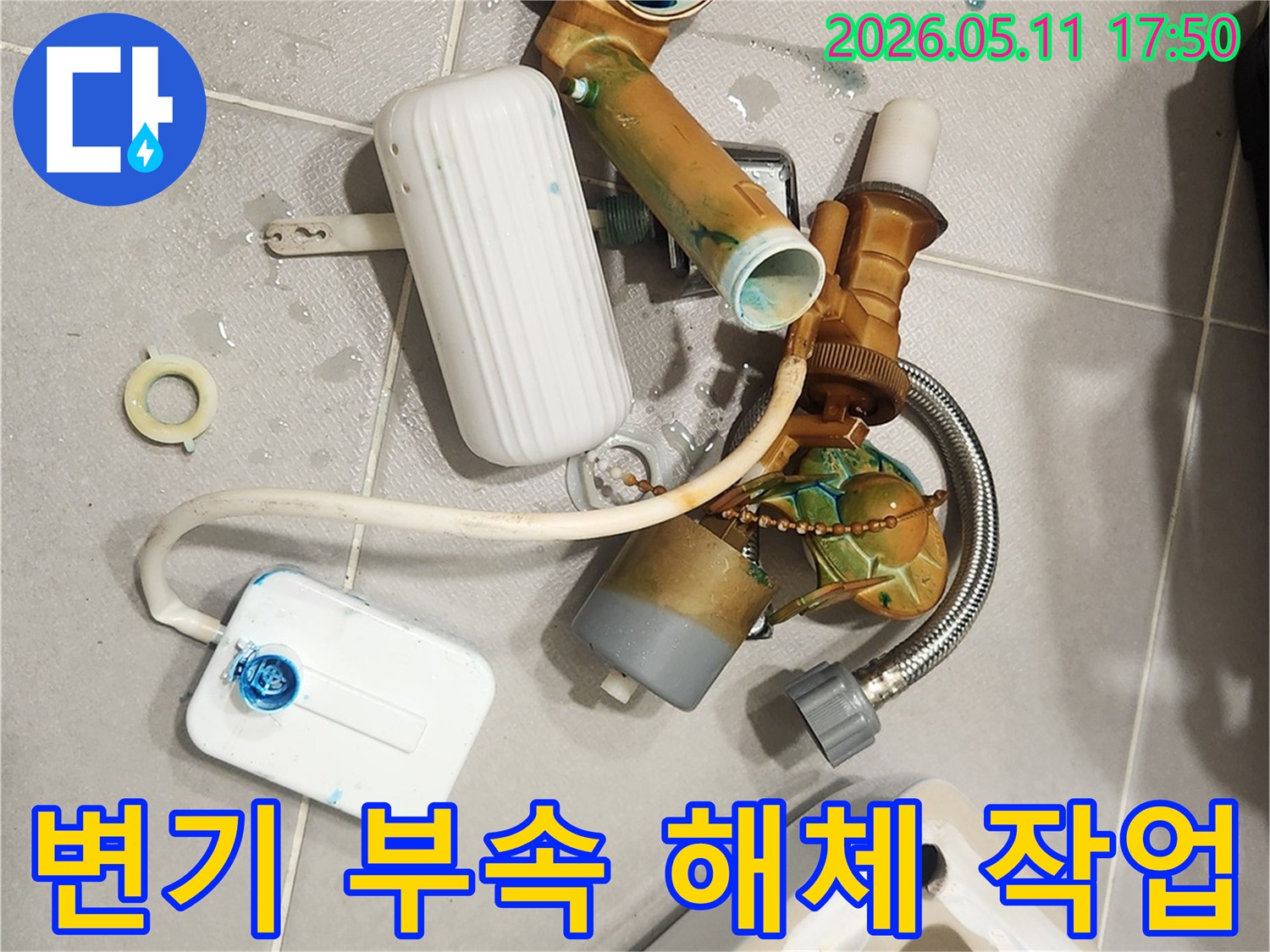 안방 변기에서 발생한 물샘 문제를 해결하기 위해-오래된 변기 부속들이 해체되어 바닥에 놓여 있는 모습입니다-새 부품으로 교체하여 변기를 수리할 예정입니다