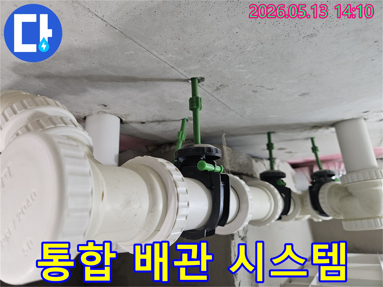콘크리트 천장 아래-서로 유기적으로 연결된 흰색 배관과 검은색 밸브들의 전체 시스템 모습