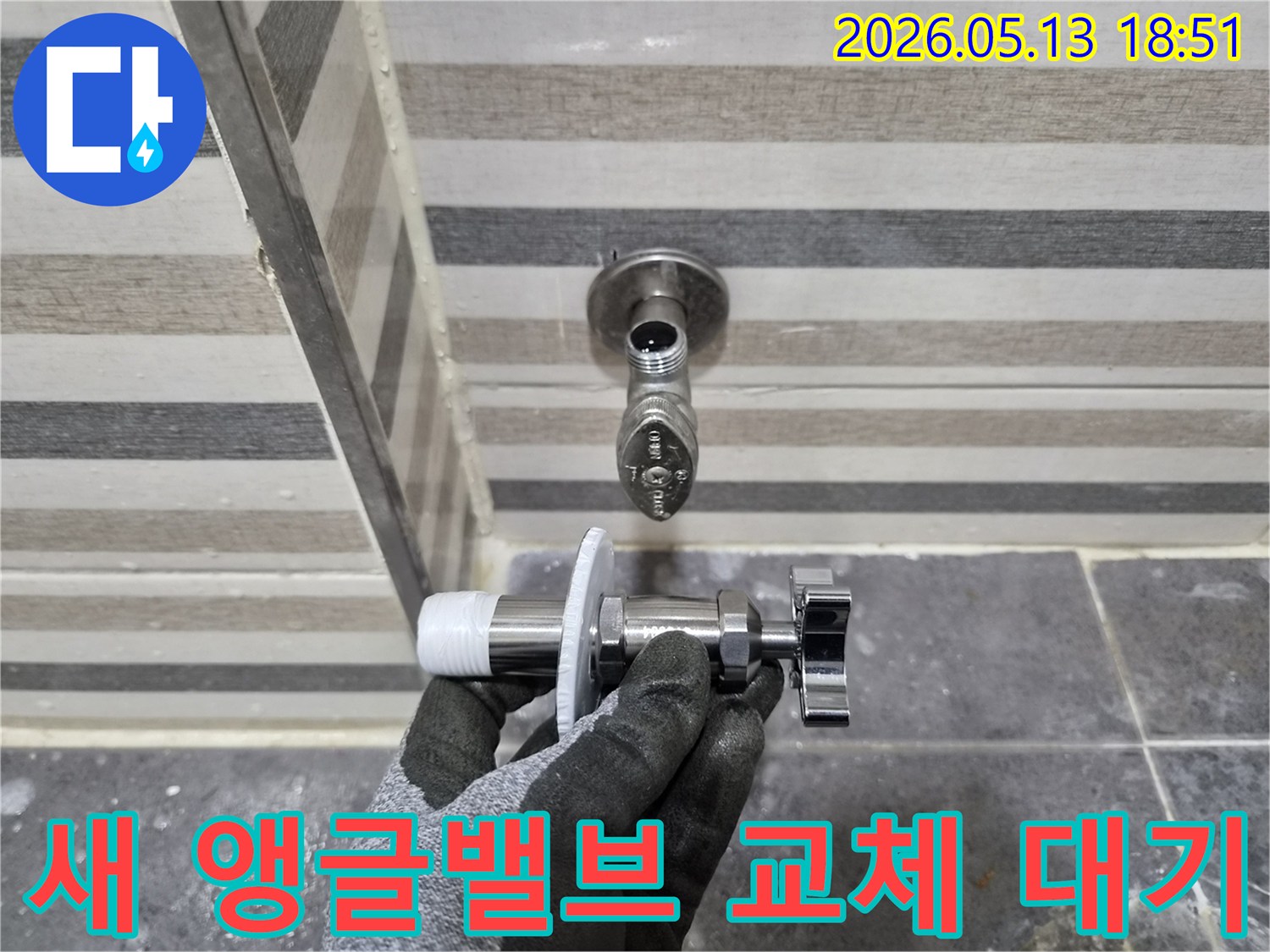 아파트 누수 수리를 위해-엔지니어가 새 앵글밸브를 손에 들고-교체 작업을 준비하고 있습니다.