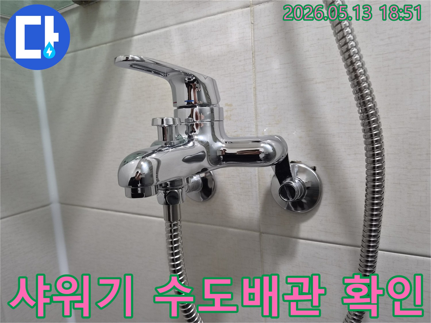욕실 벽에 설치된 크롬 샤워 수전-아래로 연결된 샤워 호스-수도배관 누수 확인을 위한 중요 지점