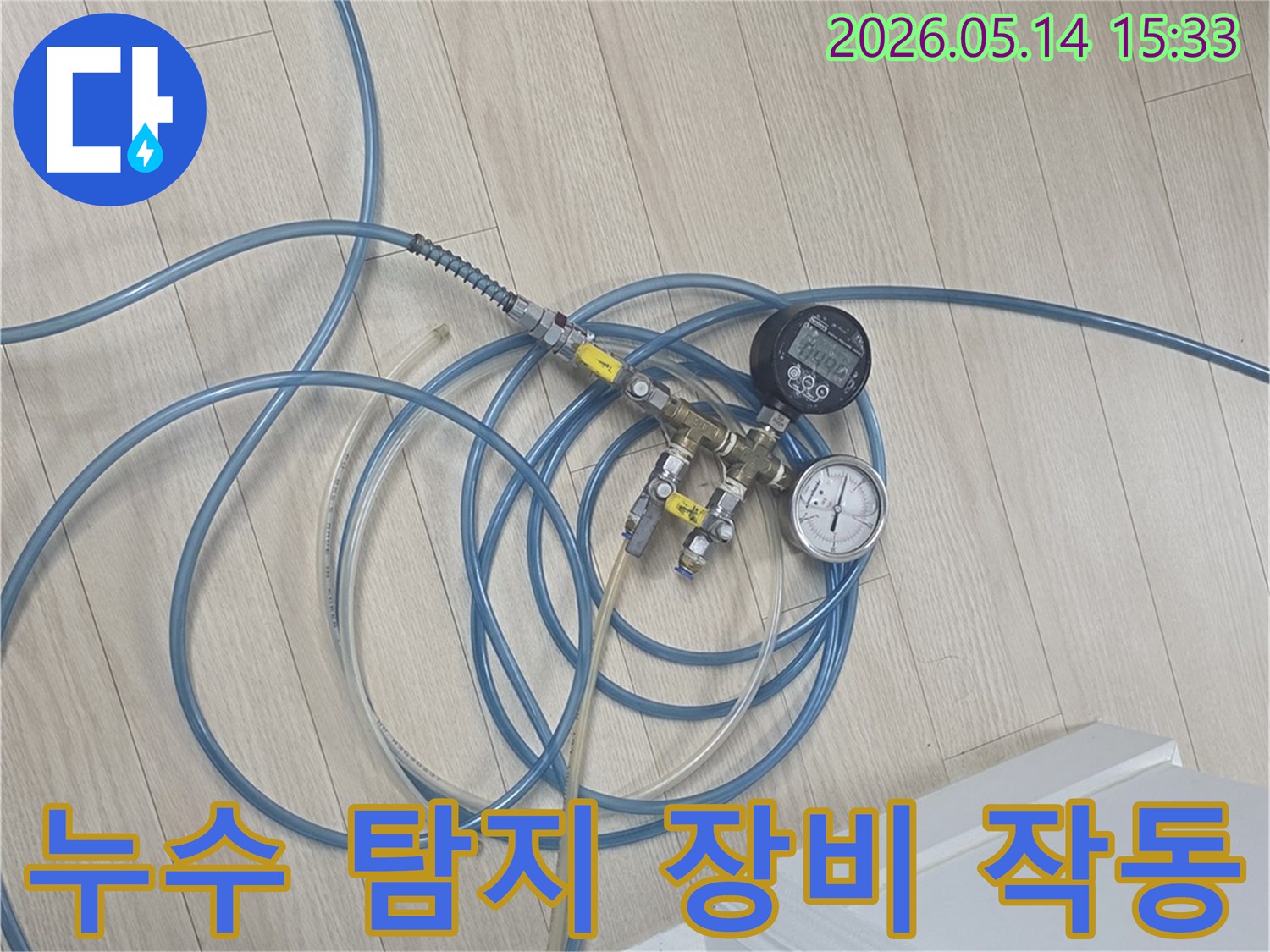 누수 탐지를 위해-압력 게이지와-호스가 연결된-전문 장비가-바닥에 설치된 모습